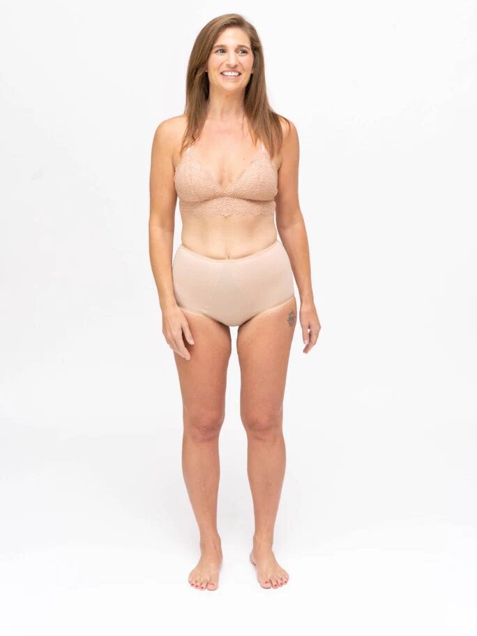 A model wearing nude high-waist Dear Kate period underwear. 