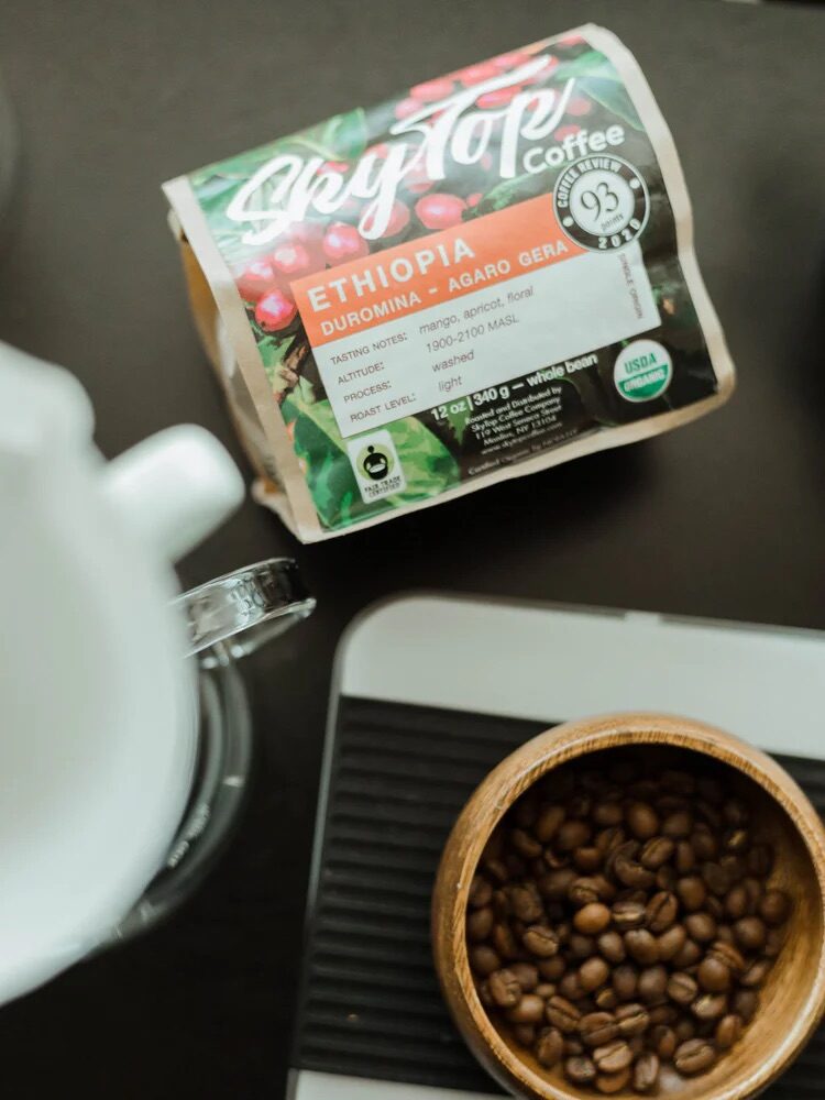 A bag of coffee from Better Grounds next to a cup of coffee beans on a scale. 