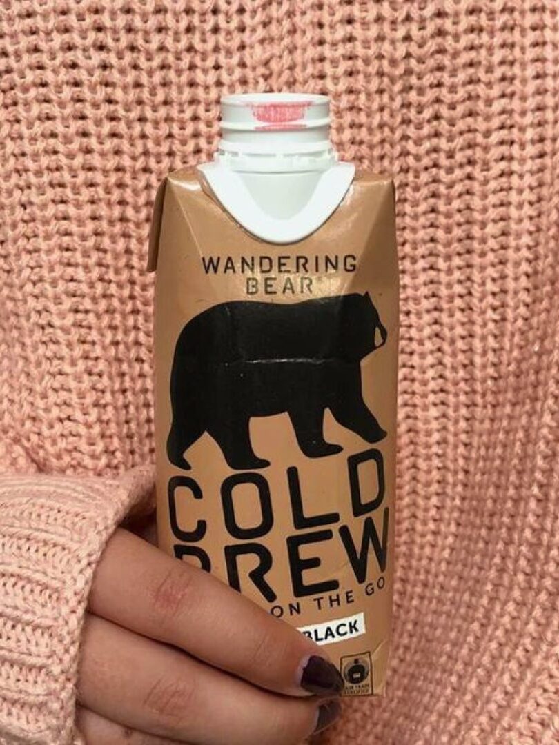 A hand holding a box of Wandering Bear Cold Brew. 