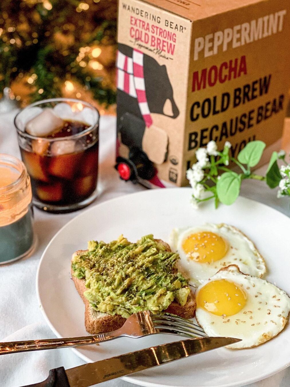 A plate of avocado toast & eggs, with Wandering Bear's Cold Brew box in the background. 