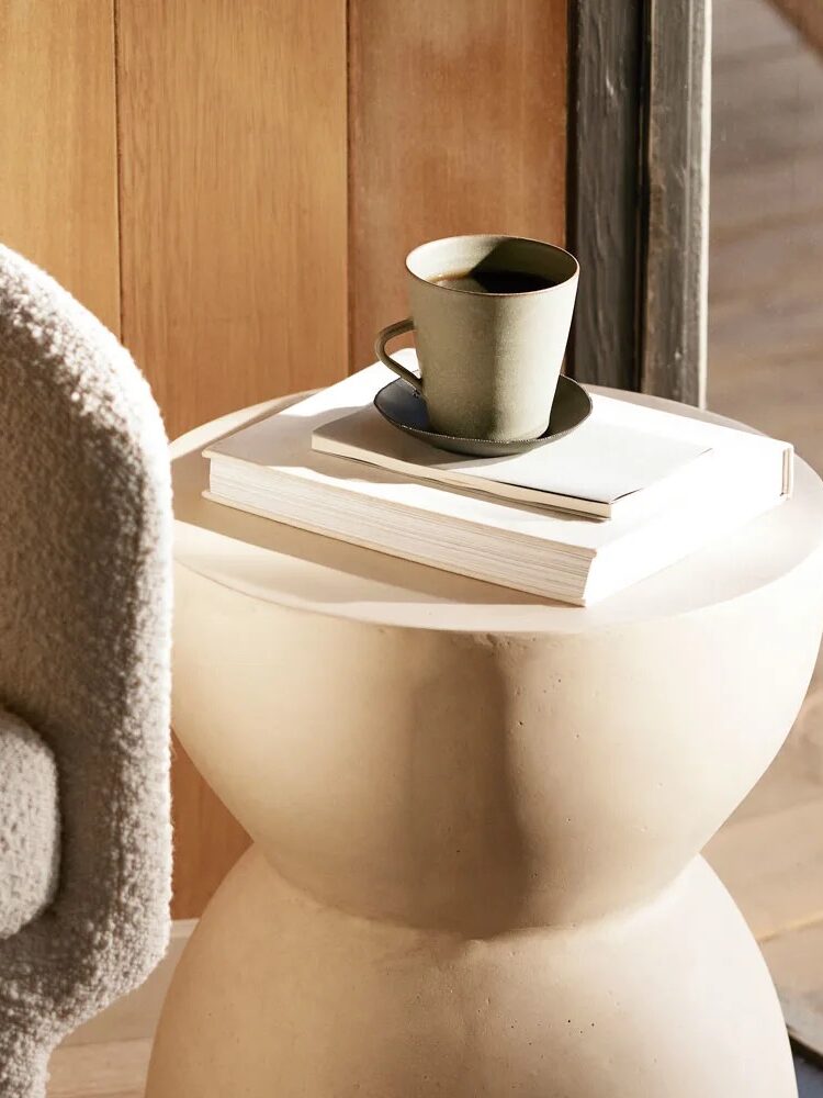 A mug of coffee set on top of coffee table books. 