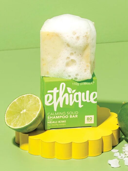 A sudsy ethique shampoo bar on top of its packaging. 