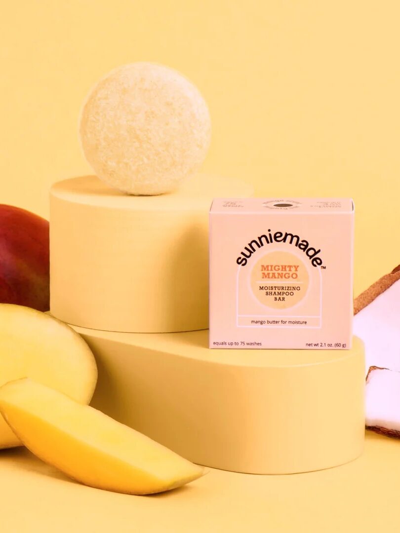 A Sunniemade mango shampoo bar next to its packaging and ingredients. 