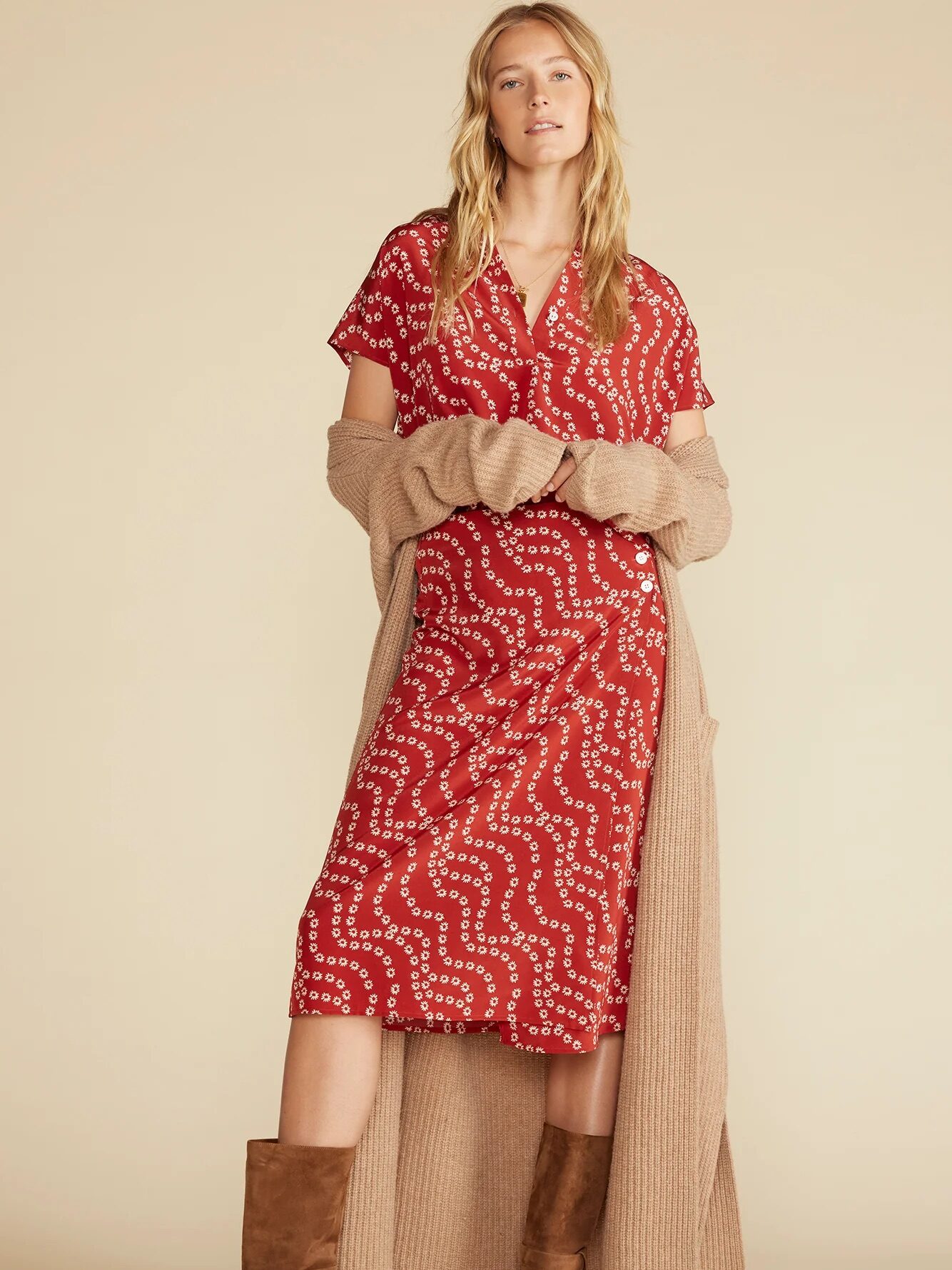 A model wearing a rust red-colored silk skirt with small white flowers in a squiggle pattern throughout, from Amour Vert. 