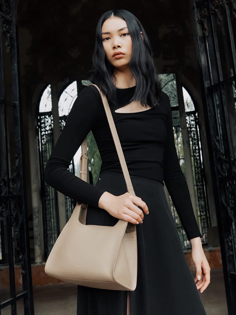 A model wearing a Cuyana crossbody bag.