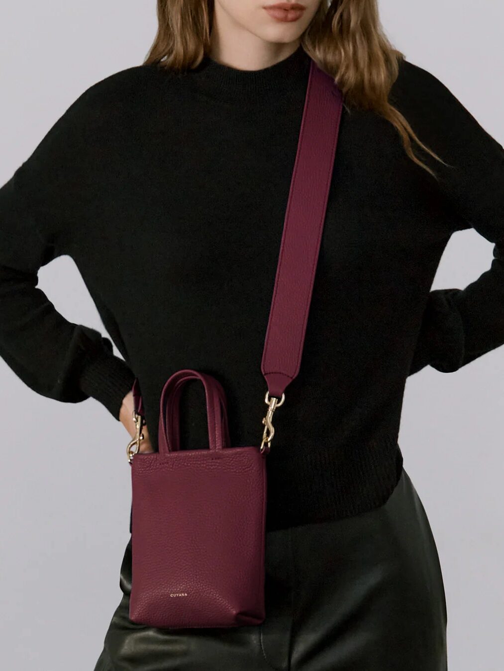 A model wearing a Cuyana crossbody bag.