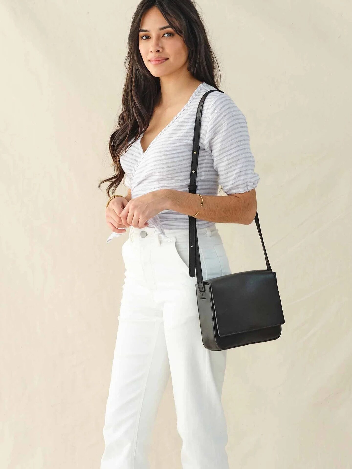 A model wearing a Nisolo crossbody bag. 