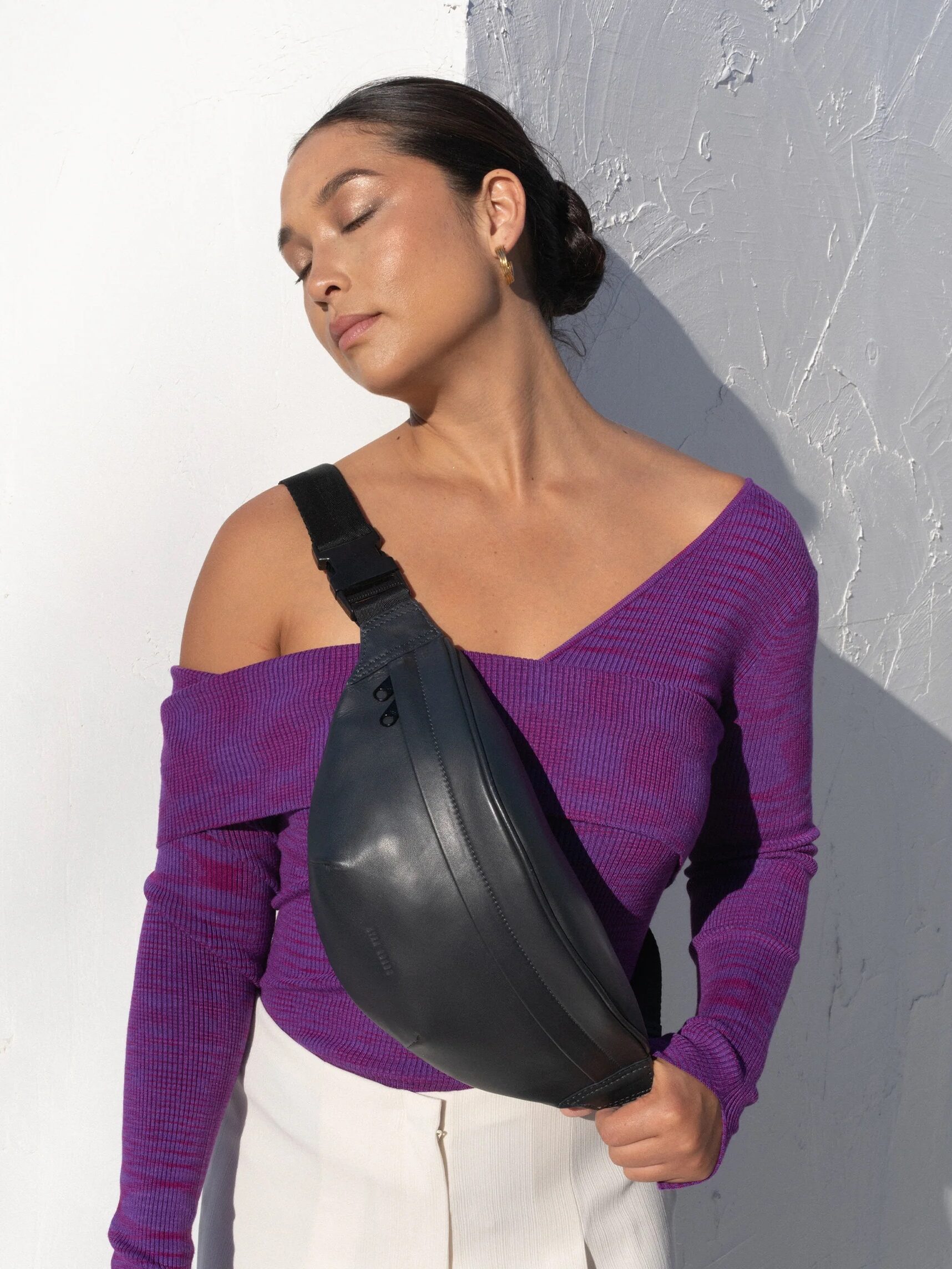 A model wearing a HYER GOODS sling bag.