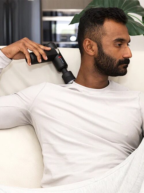 A model using a Bon Charge Heat & Cold Therapy Massage Gun. 