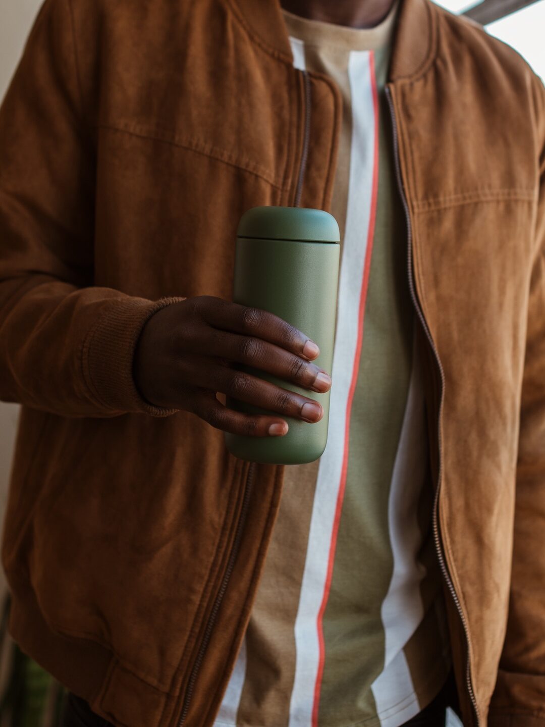 A model holding a Fellow coffee mug. 