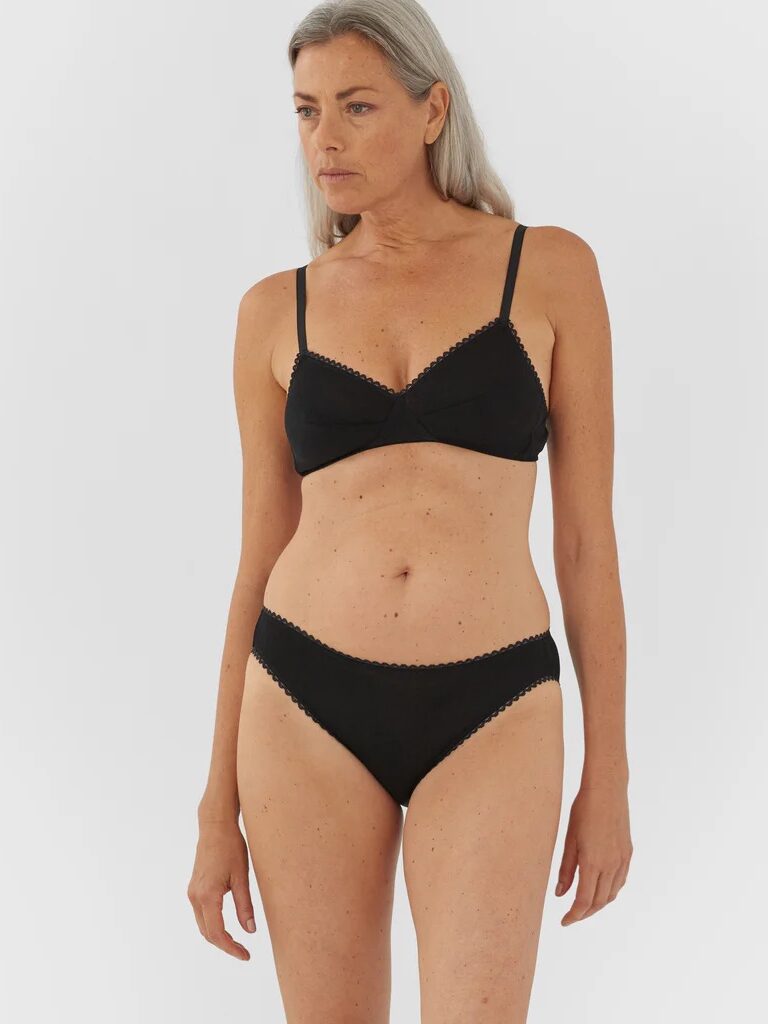 A model wearing a black matching lingerie set from Araks. 