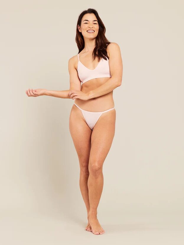 A model wearing a matching light pink intimates set from Boody. 