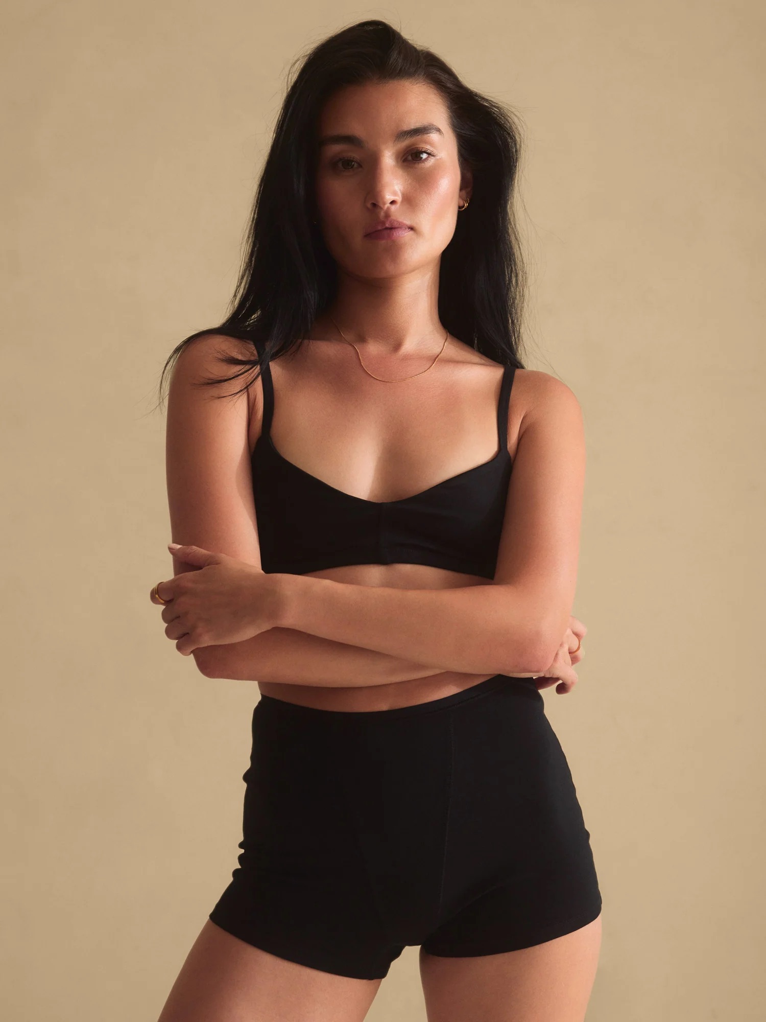 A model wearing a matching black lingerie set from MATE the Label. 