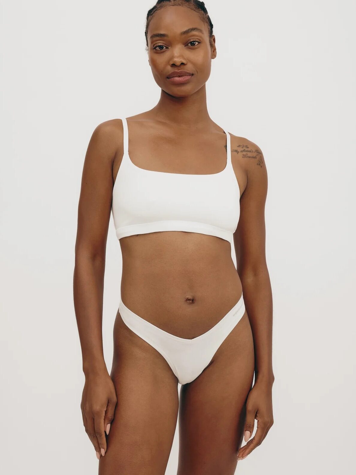 A model wearing a matching white lingerie set from Organic Basics. 