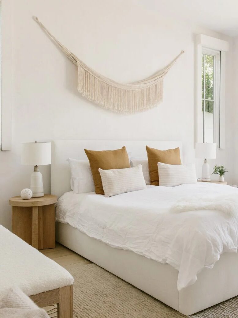 A hanging fringe wall tapestry placed above a bed, from Jenni Kayne.