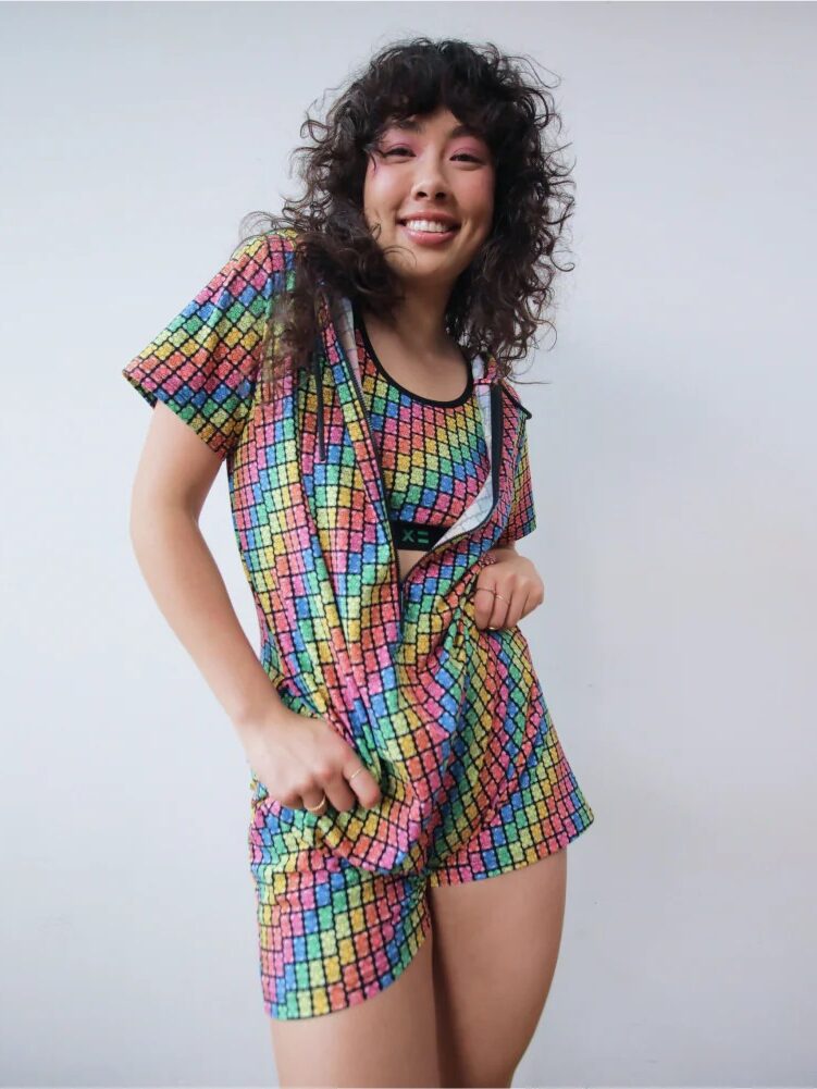 A model wearing a colorful checkered zip up romper.