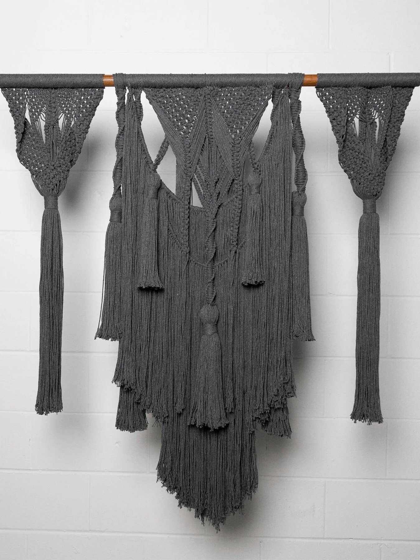 A grey woven macrame tapestry from Obakki.  