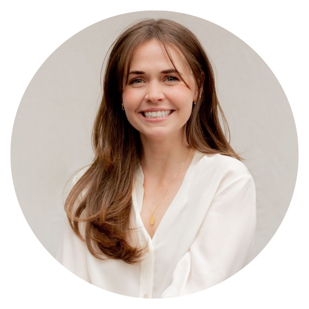 Kate Arceo, a woman with long brown hair smiles while wearing a white top.