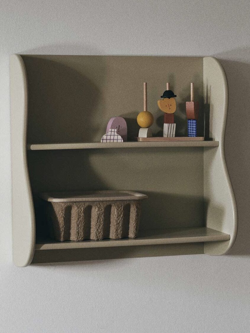 A small wall shelf with decorative wooden figurines on the top shelf and a wicker basket on the bottom shelf.