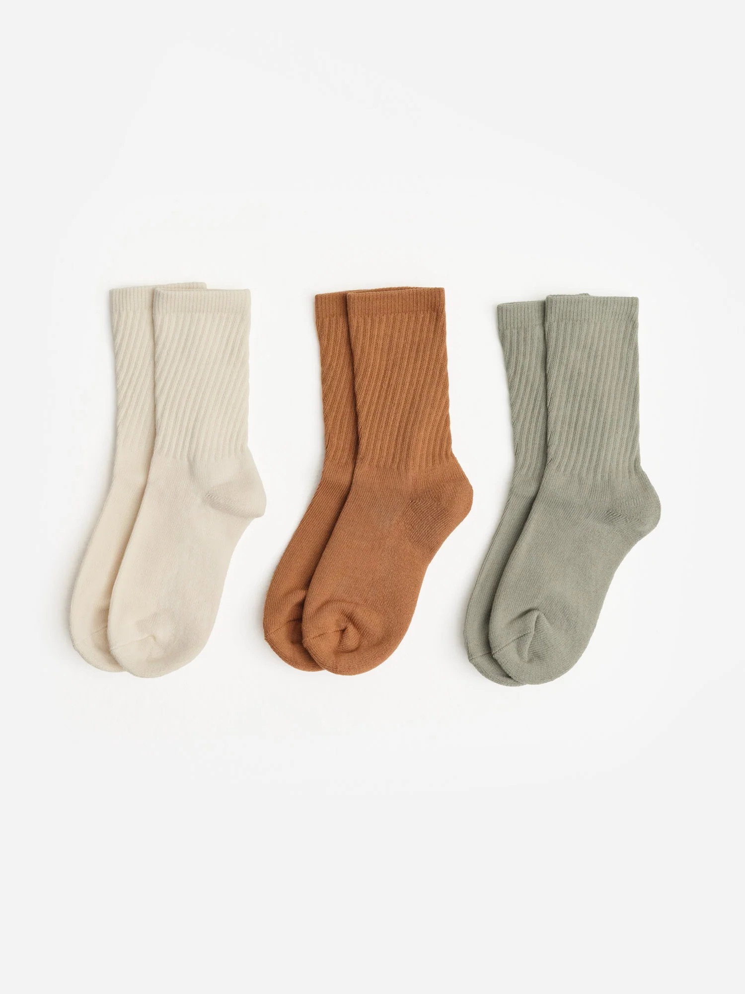 Three pairs of organic socks in beige, brown, and gray are arranged side by side on a white background.