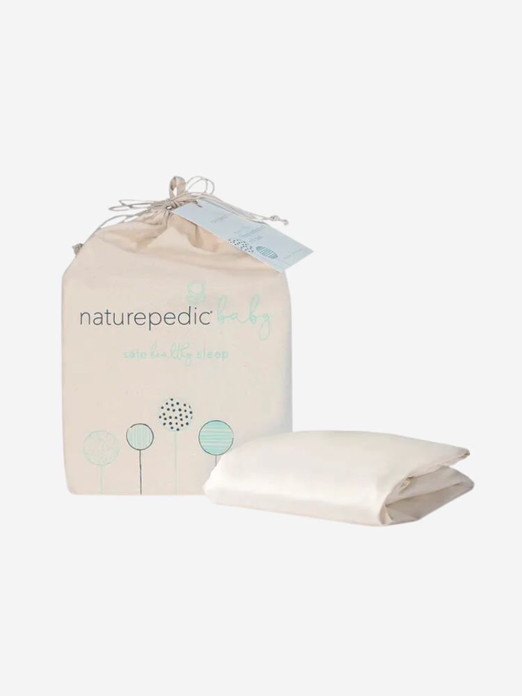 A bundle of a Naturepedic baby bedding set with a packaging bag and folded sheet displayed on a white background.