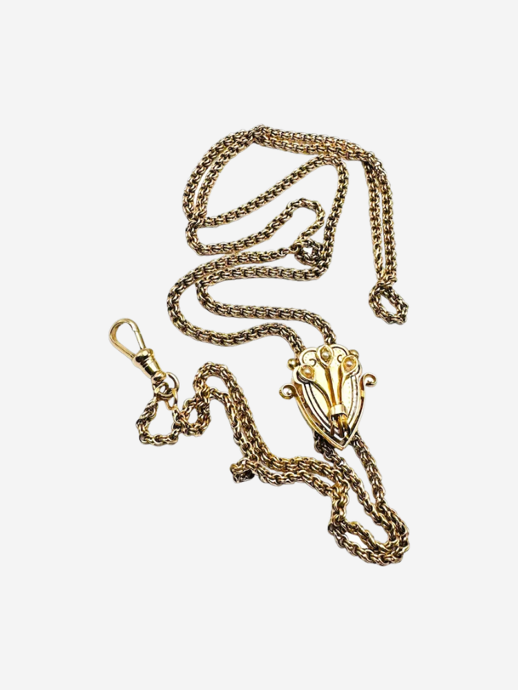 A gold chain with a decorative pendant and clasp, featuring intricate designs.