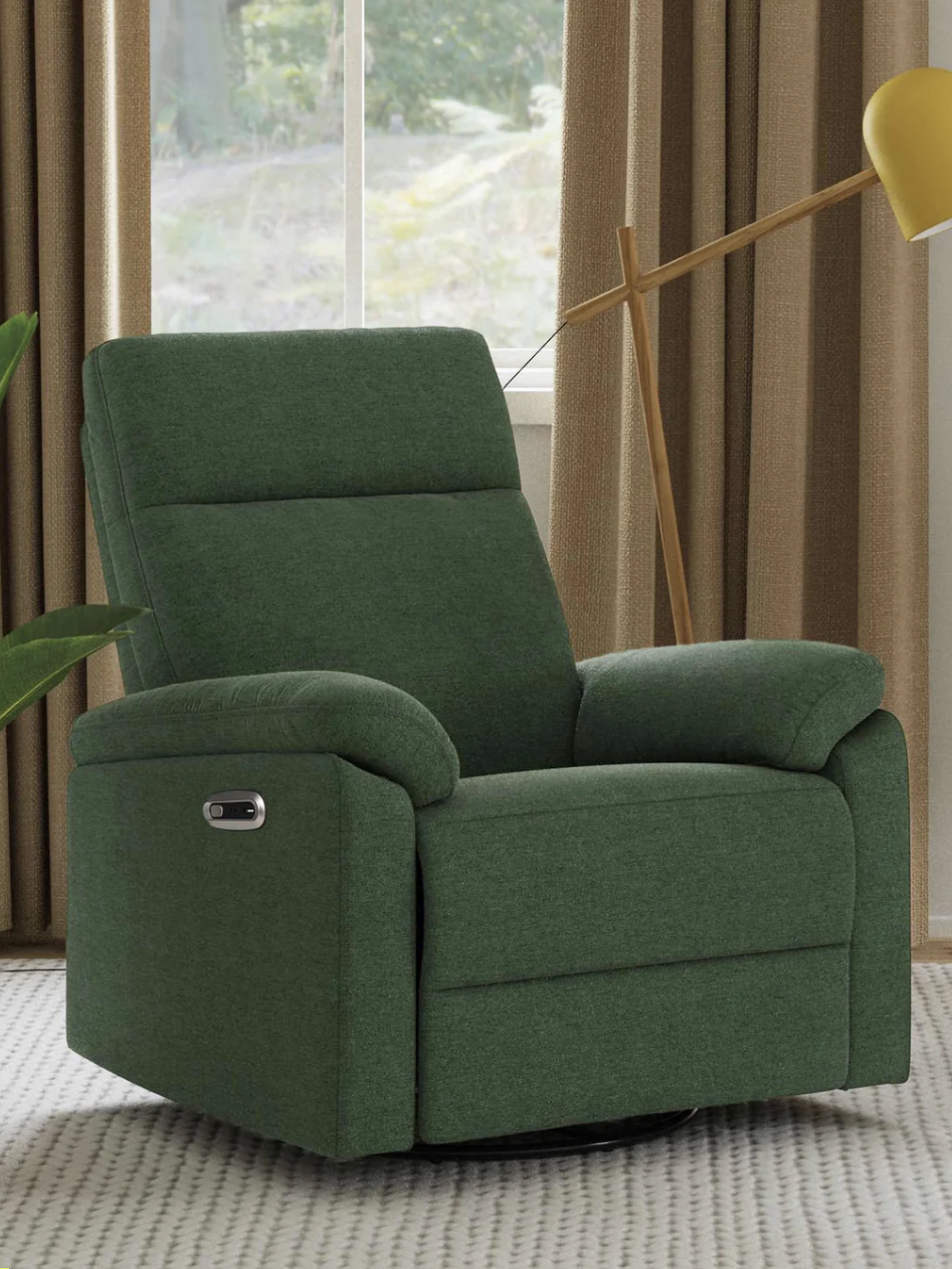 Green upholstered recliner chair in a room with brown curtains, a yellow floor lamp, and a plant, on a light-colored patterned rug.