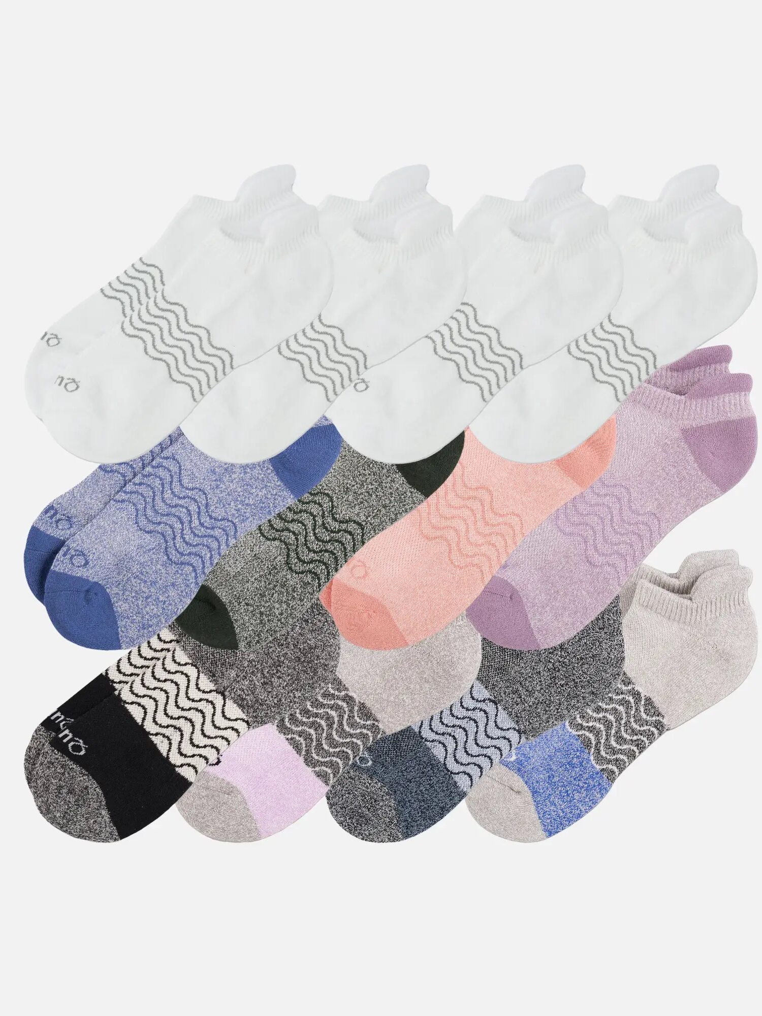 A dozen pairs of organic ankle socks in various colors and patterns are arranged in rows on a white background.