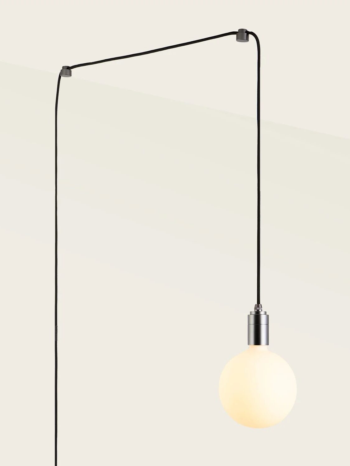 A hanging light bulb is suspended from a black cord attached to the ceiling, casting a warm glow.