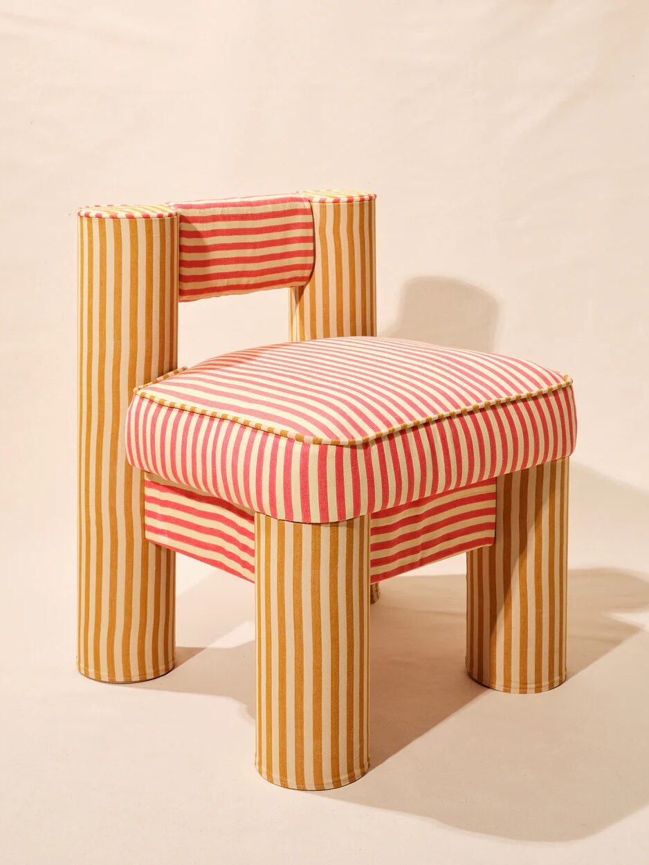 A chair with a unique design featuring bold red and yellow vertical stripes, cylindrical legs, and a padded seat and backrest.