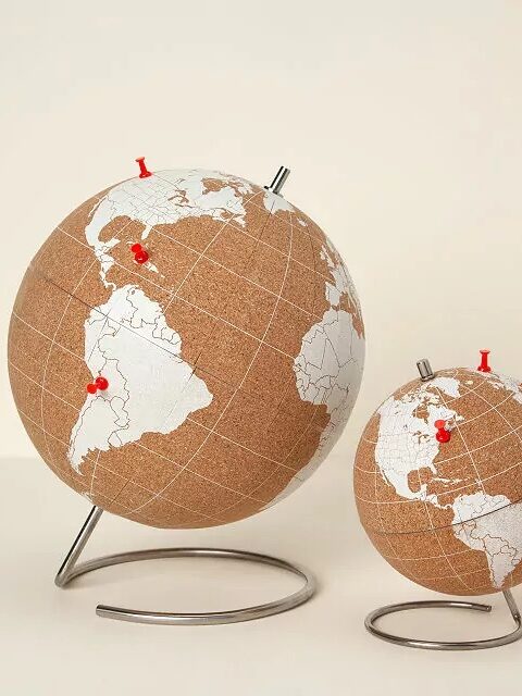 Two cork globes of different sizes on metal stands with red pins marking locations.