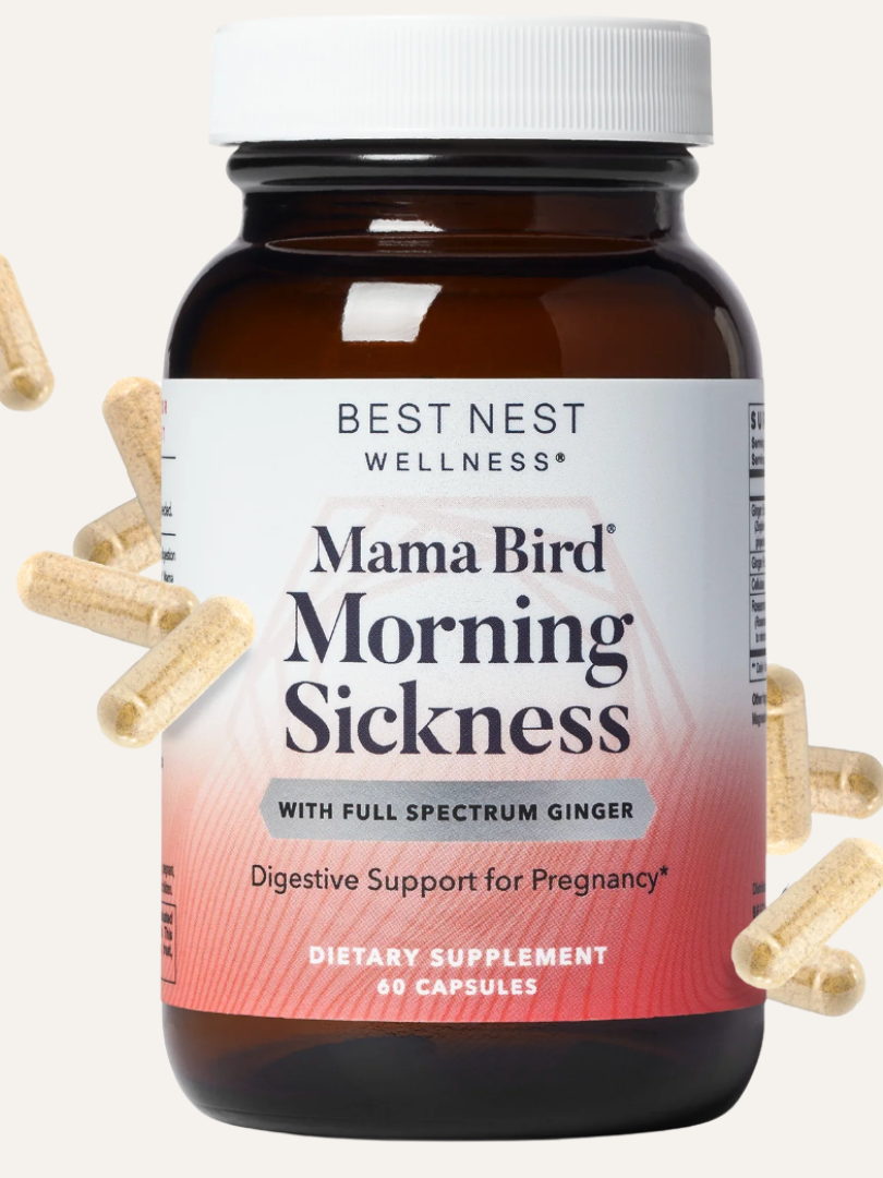 A bottle of "Mama Bird Morning Sickness" dietary supplement by Best Nest Wellness, with floating capsules around it. The label mentions digestive support for pregnancy and contains 60 capsules.