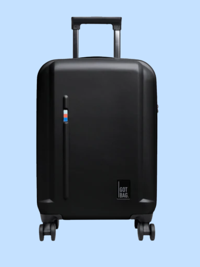 A black rolling suitcase with four wheels and a retractable handle, featuring a small multicolored rectangular design on the front.