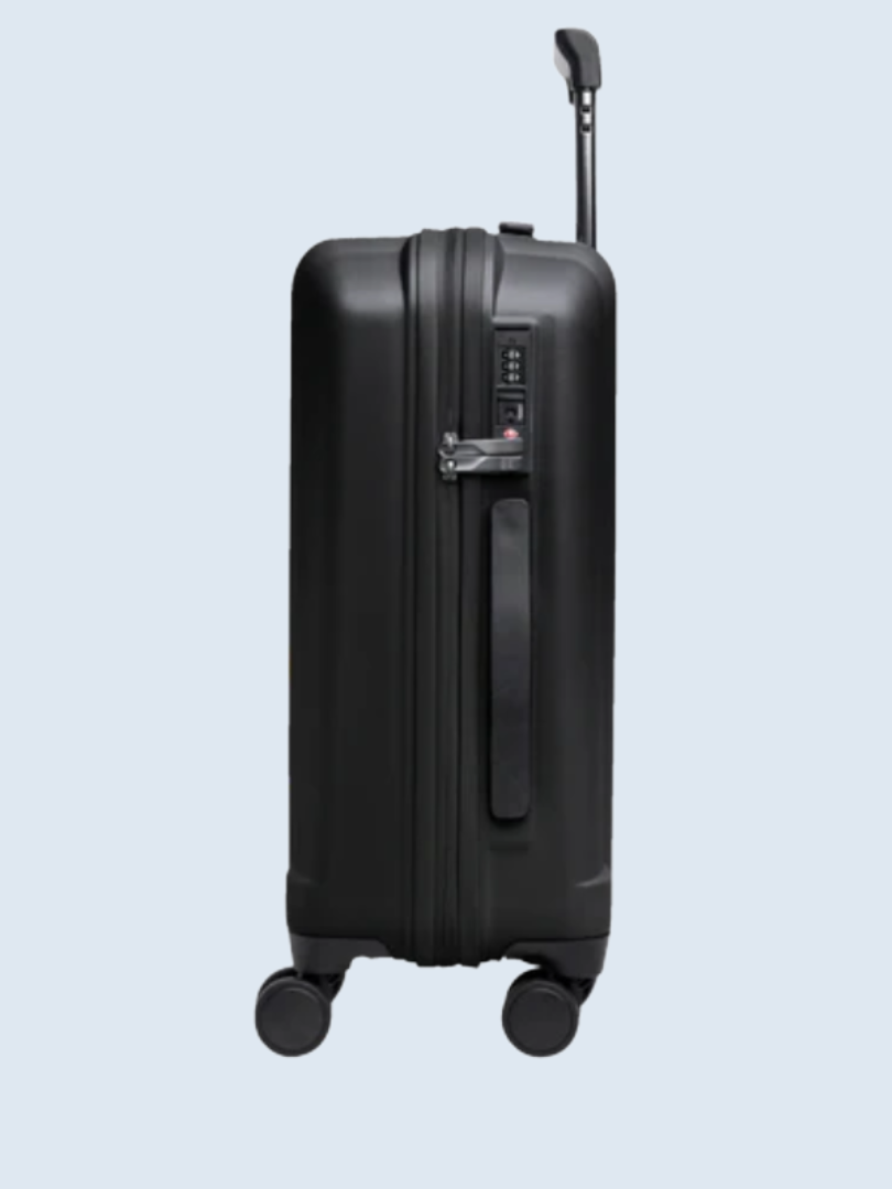 A black rolling suitcase with a telescopic handle and four wheels, positioned upright against a light blue background.