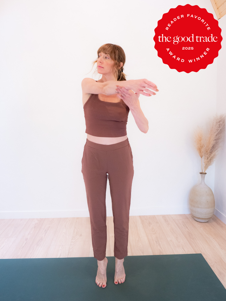 Person in brown workout attire stretches arms on a yoga mat. Red "The Good Trade 2025 Reader Favorite Award Winner" badge in the top corner.