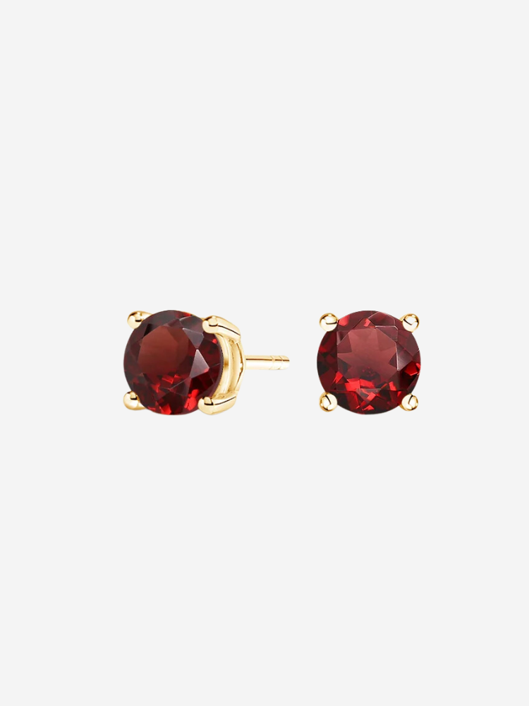 Gold stud earrings with round red gemstones on a white background.