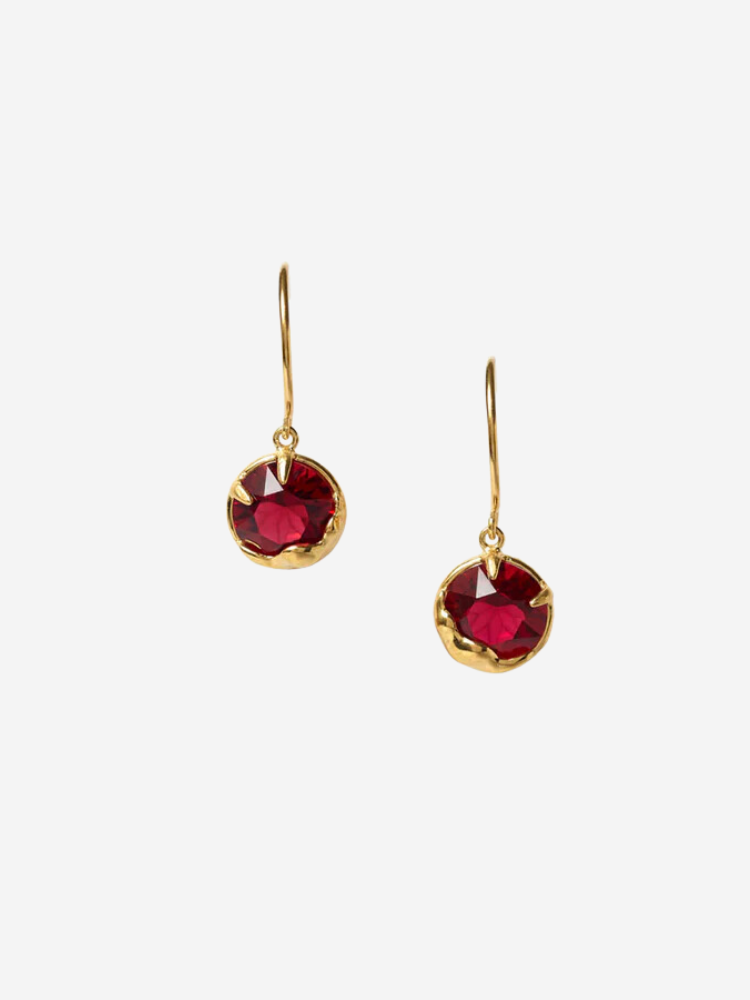 Gold earrings with red gemstones, featuring hook-style clasps, displayed against a plain white background.