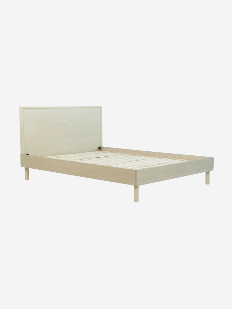 A minimalist wooden bed frame with a low headboard, shown against a plain white background.