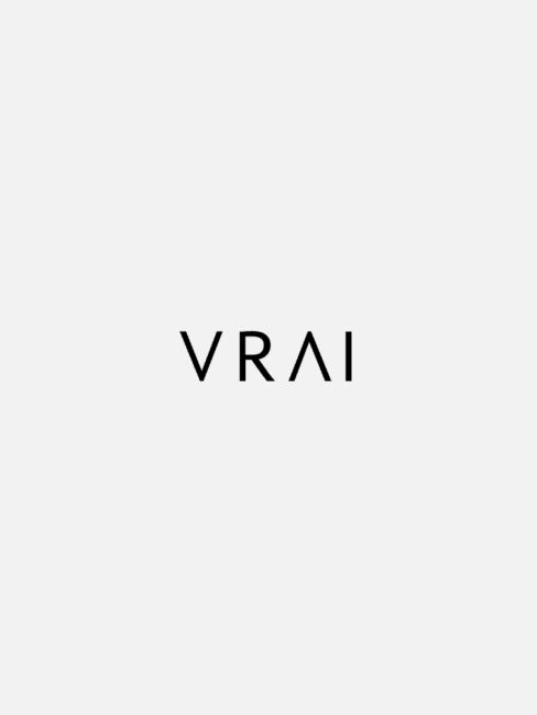The image displays the word "VRAI" in black, capitalized letters against a plain white background.
